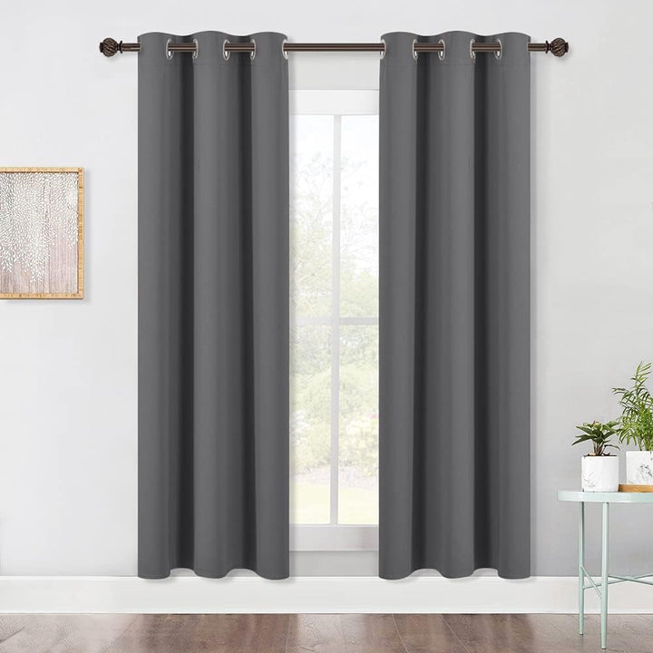 Pair of grey 42 x 72 in blackout grommet curtains hanging at a window