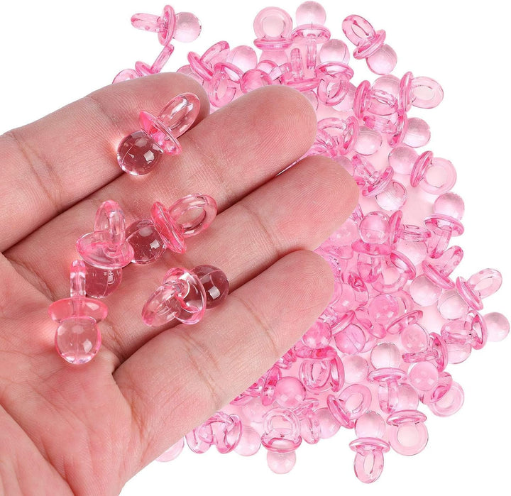 Pink mini acrylic pacifier charms held in hand