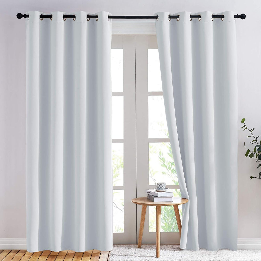 Greyish white 52 x 84 inch blackout grommet curtain pair in a room