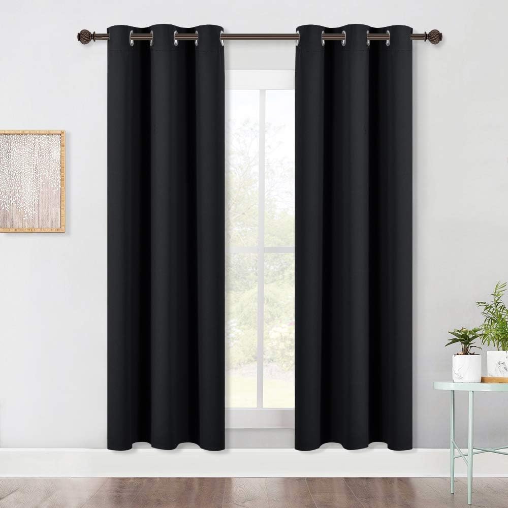 Black two-panel grommet curtains hanging at a window
