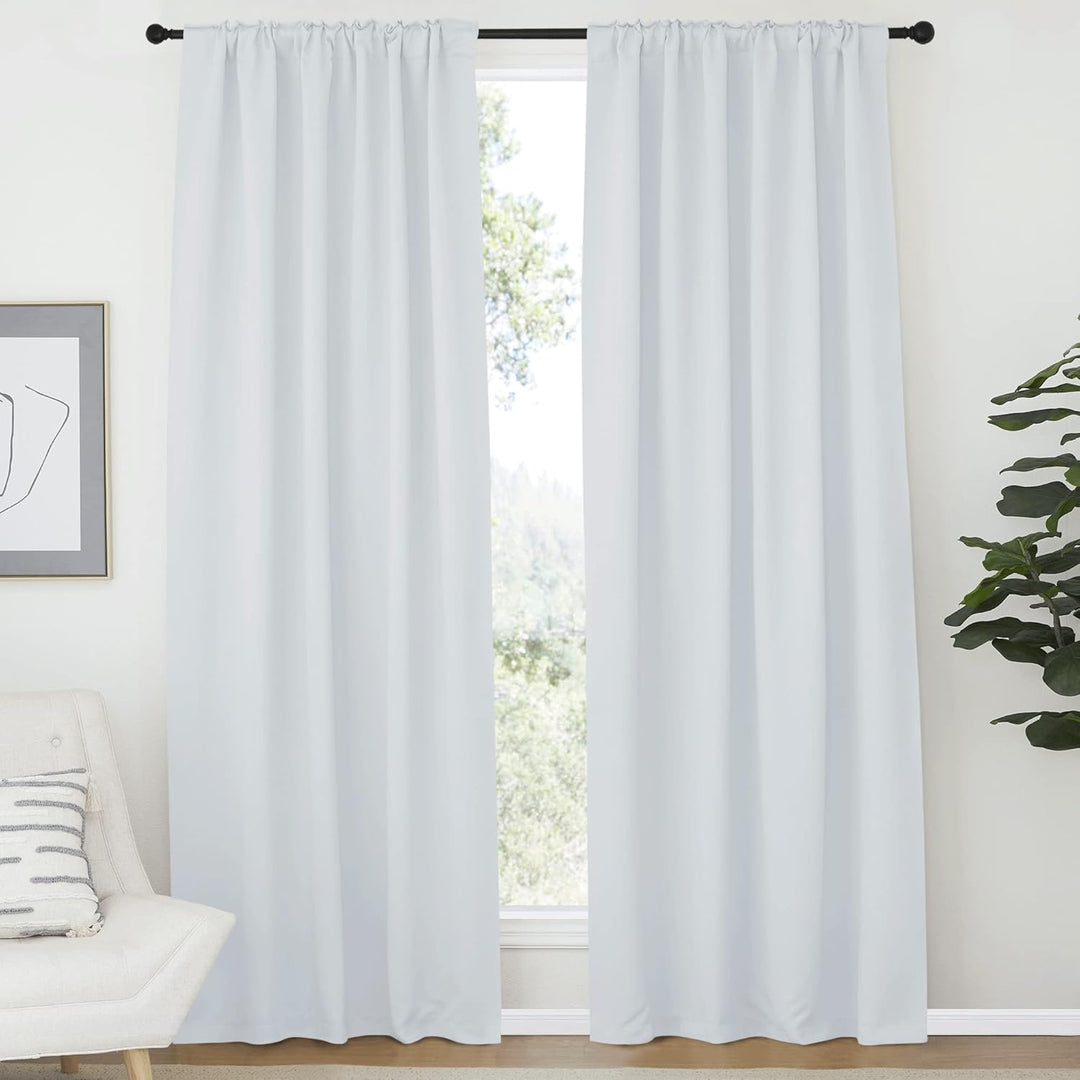 Greyish white curtains hanging from a rod pocket