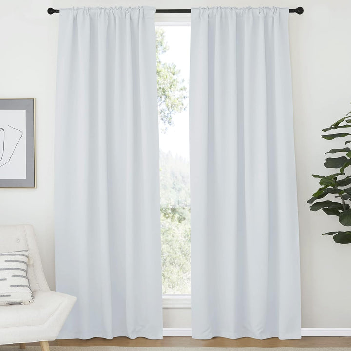 Greyish white curtains hanging from a rod pocket