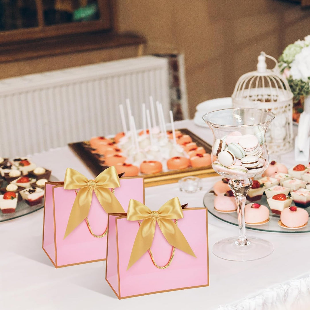 White and pink mini paper gift bags with gold handles and bows