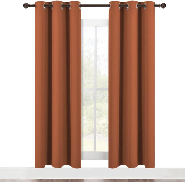 Two burnt-orange blackout curtain panels shown on a window