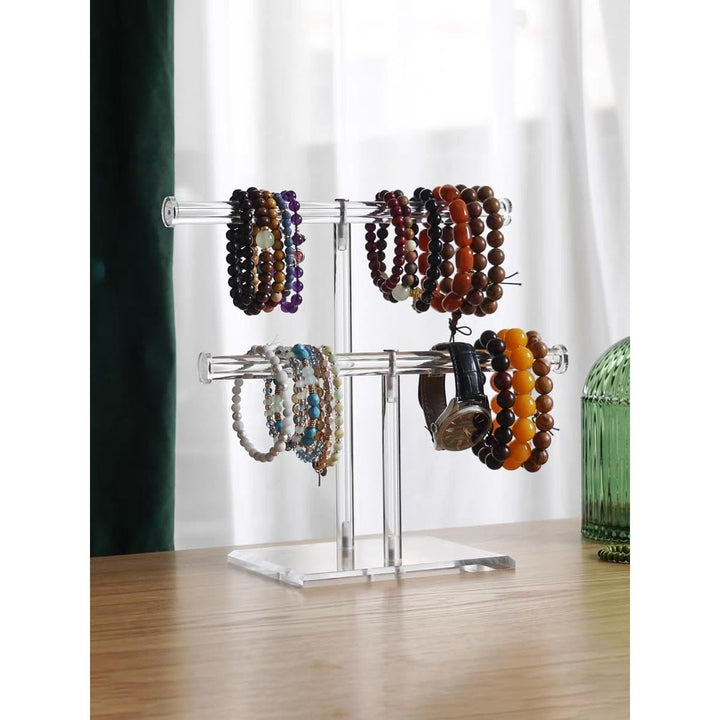 Two-tier acrylic stand displaying bracelets and a watch
