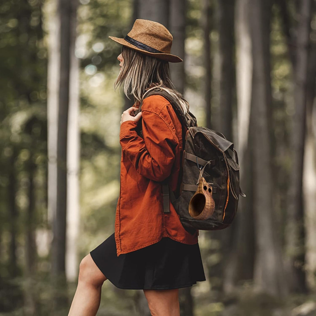Wooden camping cup hanging from a backpack